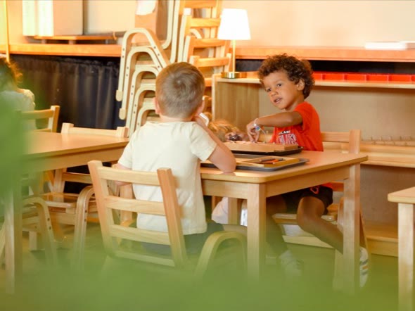 Two San Tan Montessori preschool children working together at a classroom table
